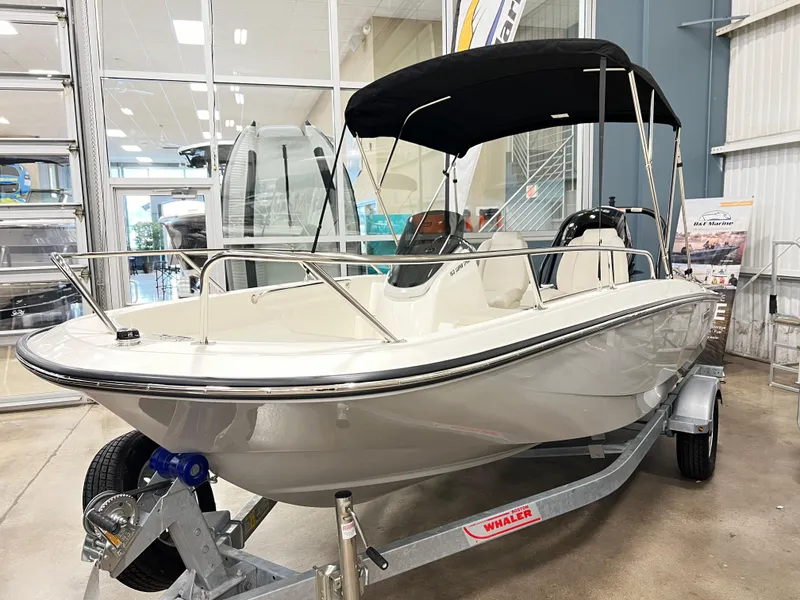 Slide: The Image of 2025 Boston Whaler 160 Super Sport boat displayed indoors on a trailer. - 1