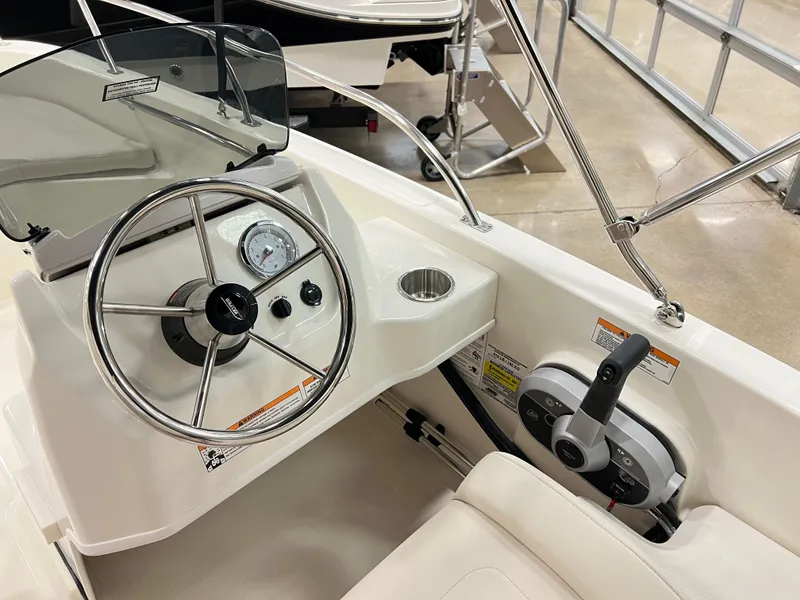 Slide: The Image of 2025 Boston Whaler 160 Super Sport boat cockpit with steering wheel and controls. - 4