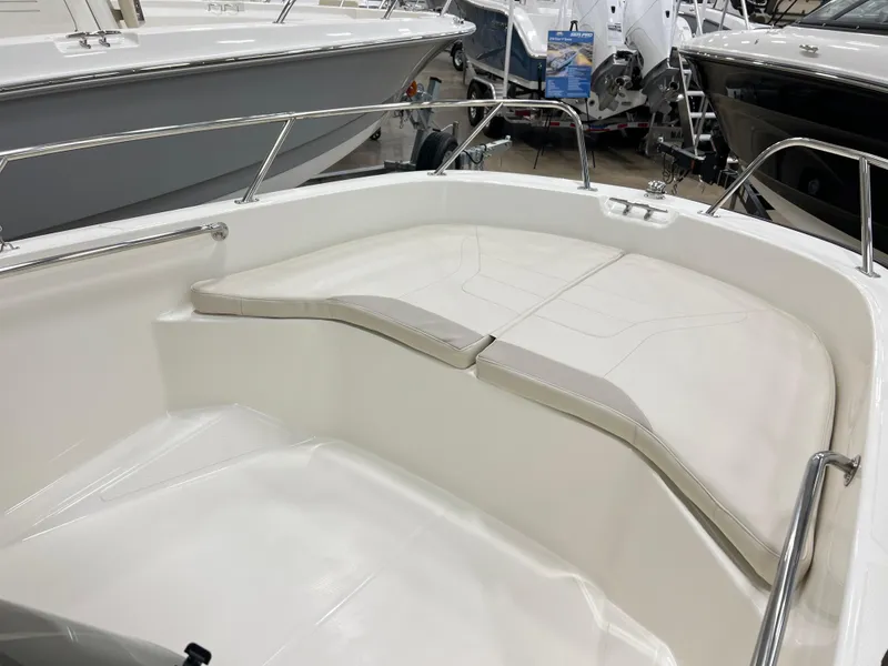 Slide: The Image of 2025 Boston Whaler 160 Super Sport boat interior with cushioned seating and sleek design. - 7