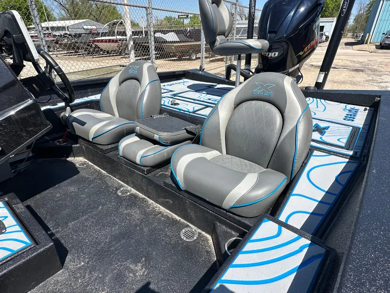 Slide: The Image of Xpress X19 Pro 2021 boat interior with gray and blue seating, featuring a powerful outboard motor. - 11