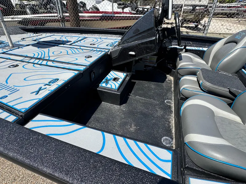 Slide: The Image of 2021 Xpress X19 Pro boat interior with gray and blue seating and deck design. - 12