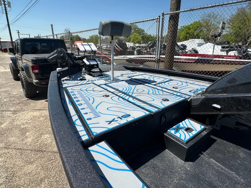 Slide: The Image of 2021 Xpress X19 Pro boat with custom deck design, parked near a fence. - 15