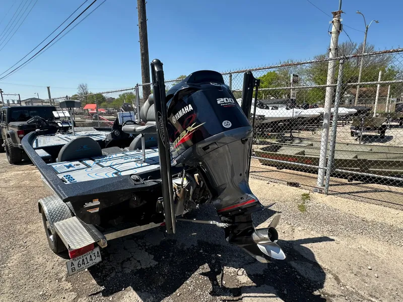 Slide: The Image of Xpress X19 Pro 2021 boat with Yamaha 200 engine on a trailer, parked outdoors. - 4