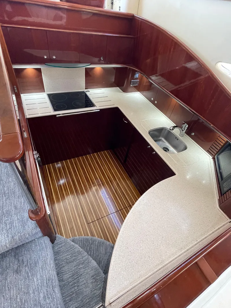 Slide: The Image of Luxurious kitchen area in 2003 Viking Princess 65 yacht with modern amenities and wood finish. - 16