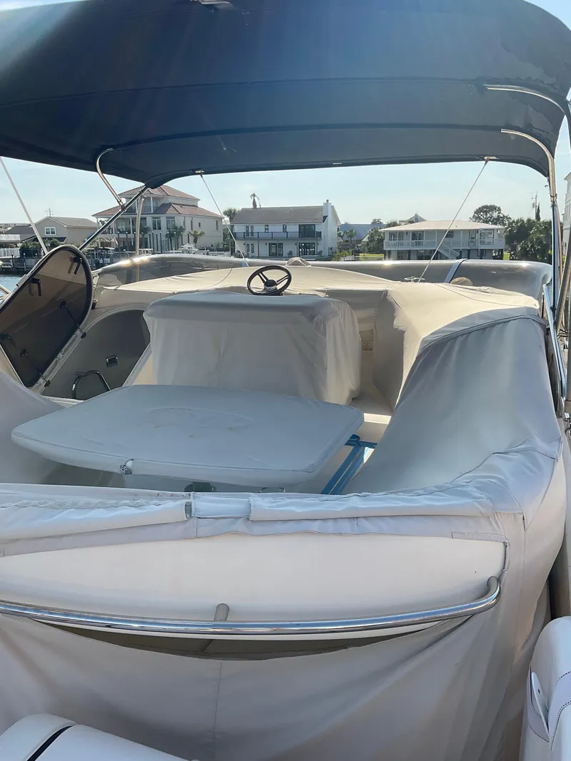 Slide: The Image of 2003 Viking Princess 65 yacht with covered seating and steering wheel, docked near waterfront homes. - 9