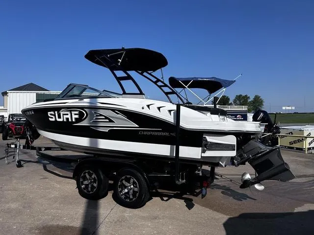 Slide: The Image of 2020 Chaparral 21 Surf boat on trailer, black and white design, parked outdoors. - 2