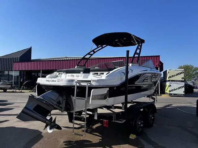 Slide: The Image of 2020 Chaparral 21 Surf boat on trailer, displayed outdoors under clear blue sky. - 3