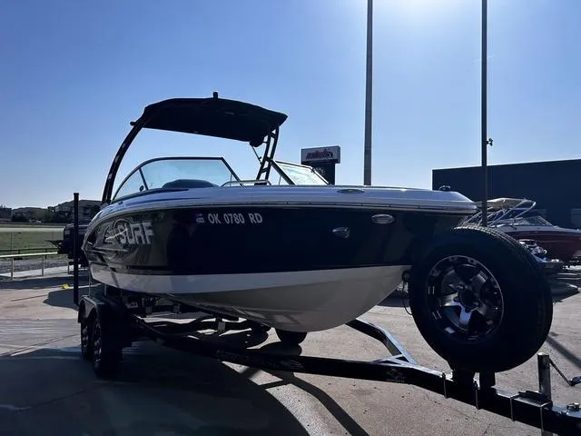 Slide: The Image of 2020 Chaparral 21 Surf boat on trailer, parked outdoors under clear sky. - 4