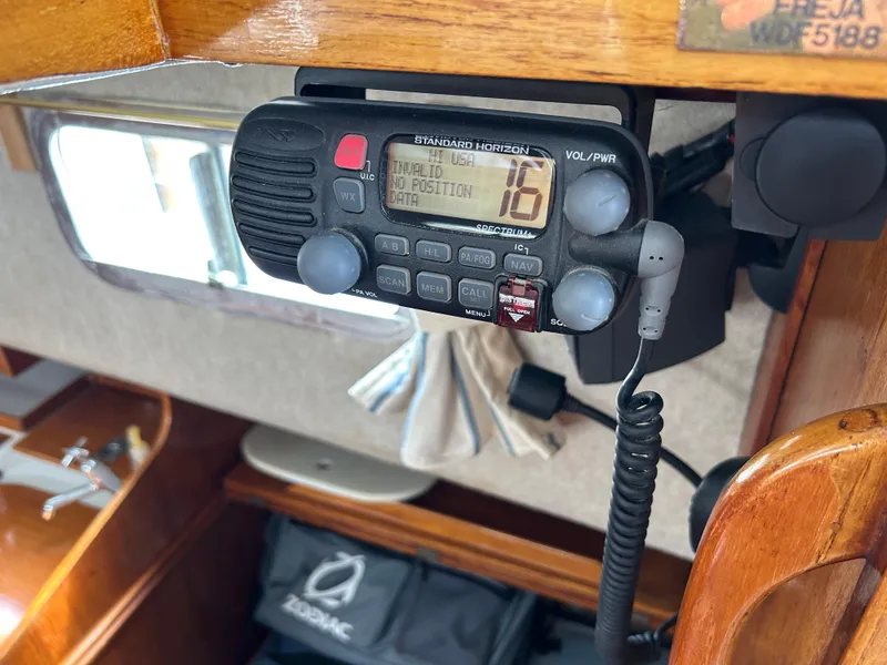 Slide: The Image of VHF radio on 1975 Fisher 30 Motorsailer, displaying channel 16 in a wooden cabin interior. - 15