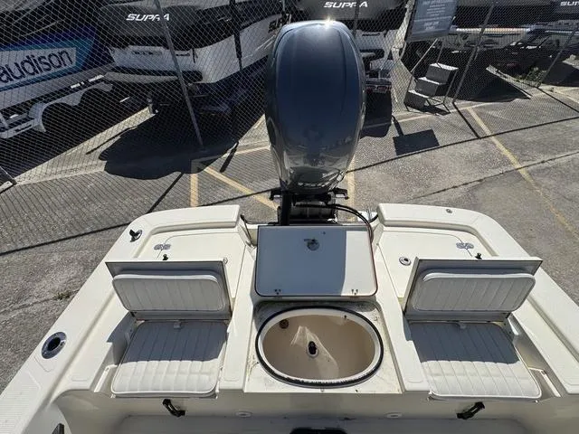 Slide: The Image of 2014 Frontier Boats 2104 with outboard motor and seating, parked near trailers. - 11
