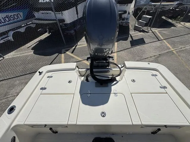 Slide: The Image of 2014 Frontier Boats 2104 with outboard motor, parked in a fenced area. - 12