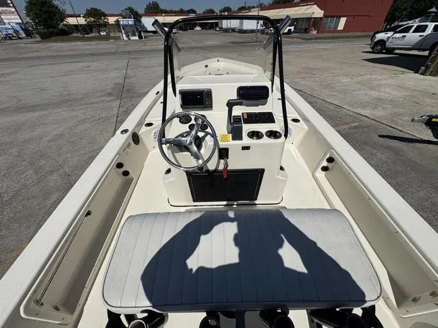 Slide: The Image of 2014 Frontier Boats 2104 interior view with steering wheel and console in a parking lot. - 15