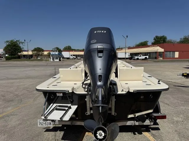 Slide: The Image of 2014 Frontier Boats 2104 with outboard motor in a parking lot. - 8