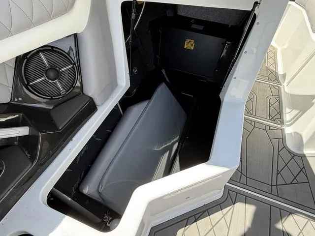 Slide: The Image of 2021 Tigé ZX Class 23 ZX boat interior storage compartment with speaker and cushioned seating. - 14