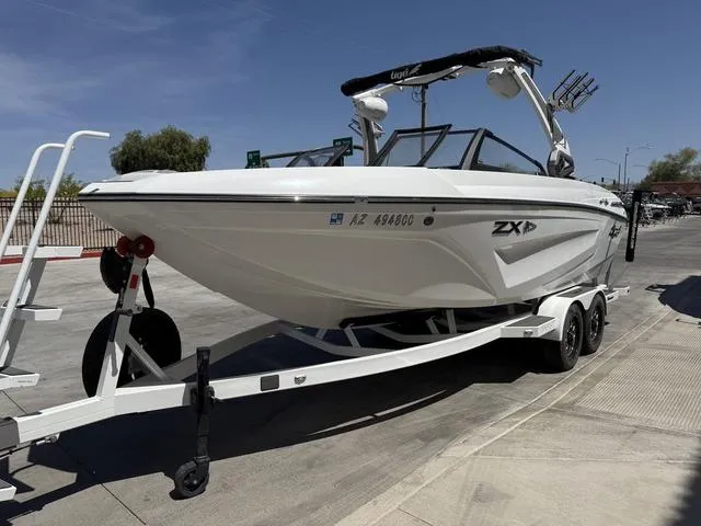 Slide: The Image of 2021 Tigé ZX Class 23 ZX boat on trailer, parked outdoors under clear sky. - 4
