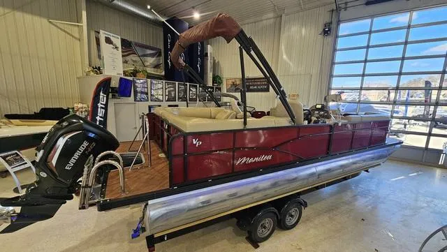 Slide: The Image of 2017 Manitou Aurora 25 LE pontoon boat on trailer in showroom. - 1