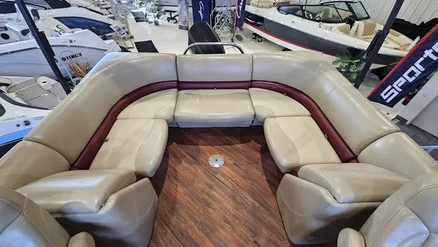 Slide: The Image of 2017 Manitou Aurora 25 LE pontoon boat interior with beige seating and wood flooring. - 10