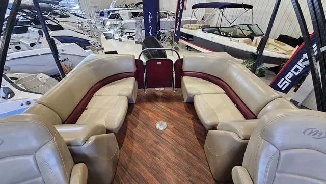 Slide: The Image of 2017 Manitou Aurora 25 LE pontoon boat interior with beige seating and wood flooring. - 11