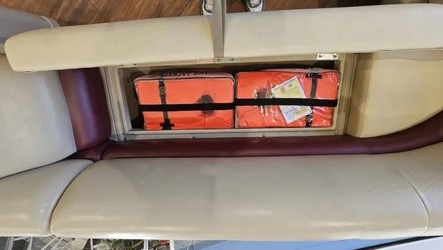 Slide: The Image of 2017 Manitou Aurora 25 LE boat seat storage with orange life jackets. - 27