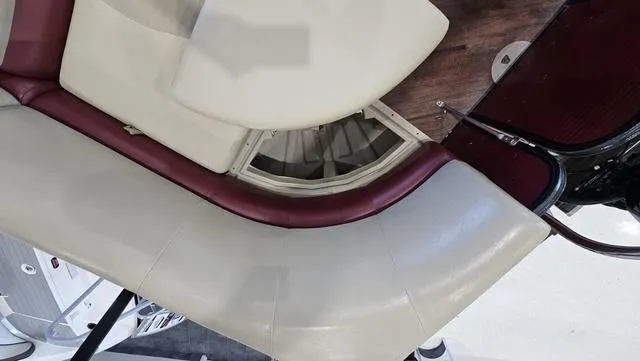 Slide: The Image of 2017 Manitou Aurora 25 LE boat seating with storage compartment, featuring beige and maroon upholstery. - 29