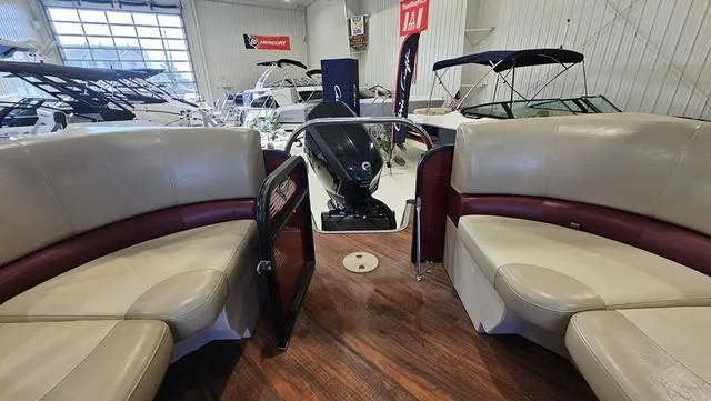Slide: The Image of 2017 Manitou Aurora 25 LE pontoon boat interior with beige seating in showroom. - 33
