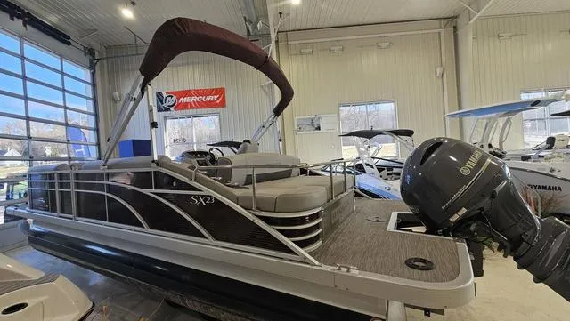 Slide: The Image of 2020 Bennington SX 23 Premium pontoon boat in showroom with Yamaha outboard motor. - 3