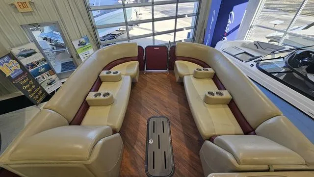 Slide: The Image of Interior of 2017 Manitou Aurora 25 LE pontoon boat with beige seating and cup holders. - 13