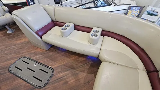 Slide: The Image of Luxurious seating in 2017 Manitou Aurora 25 LE pontoon boat with cup holders and wood flooring. - 16