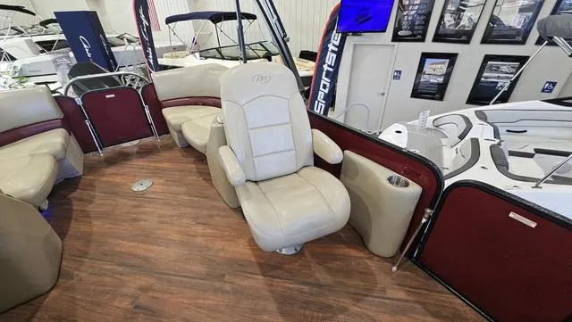 Slide: The Image of 2017 Manitou Aurora 25 LE pontoon boat interior with beige seating and wood flooring. - 17