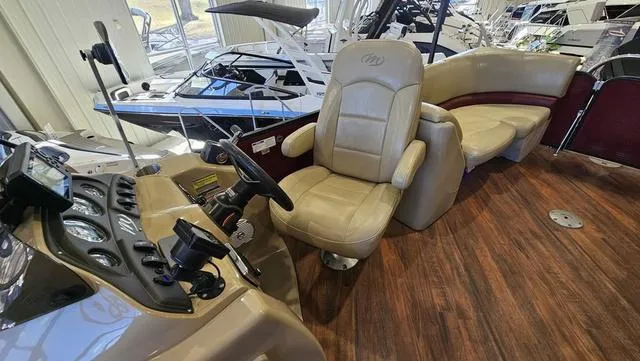 Slide: The Image of 2017 Manitou Aurora 25 LE boat interior with beige seating and wood flooring. - 18