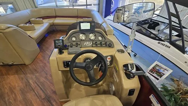 Slide: The Image of 2017 Manitou Aurora 25 LE boat interior with steering console and seating area. - 19