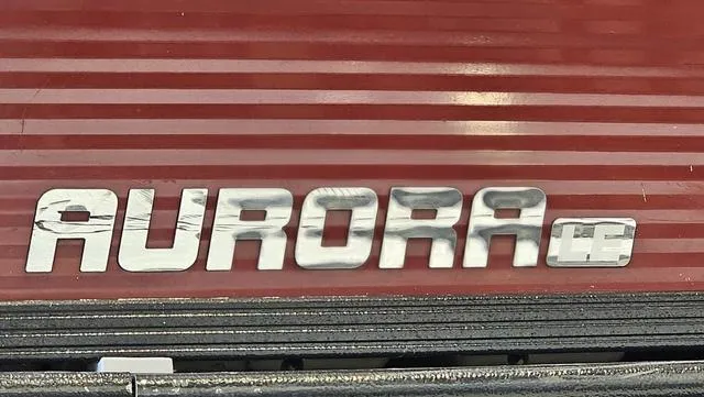 Slide: The Image of 2017 Manitou Aurora 25 LE logo on red ribbed surface. - 35