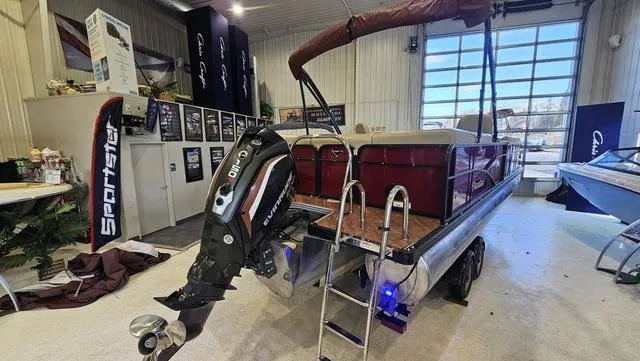 Slide: The Image of 2017 Manitou Aurora 25 LE pontoon boat in showroom with outboard motor and ladder. - 7