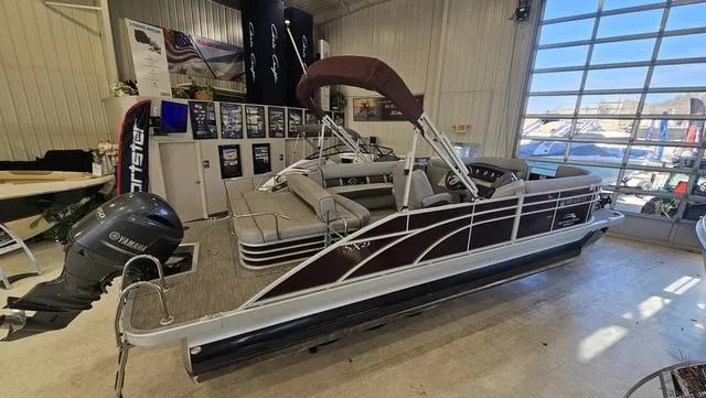 Slide: The Image of 2020 Bennington SX 23 Premium pontoon boat displayed indoors with Yamaha outboard motor. - 1
