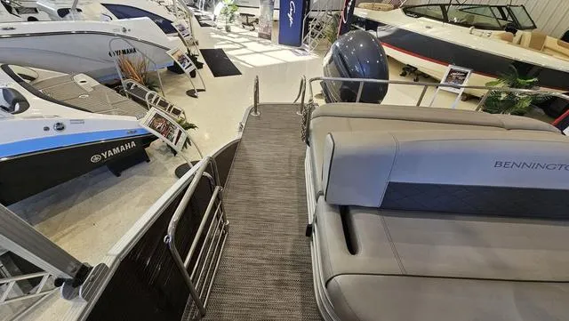 Slide: The Image of 2020 Bennington SX 23 Premium pontoon boat in showroom with Yamaha models nearby. - 21