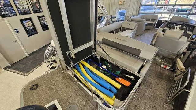 Slide: The Image of 2020 Bennington SX 23 Premium boat interior with open storage compartment and colorful pool noodles. - 22