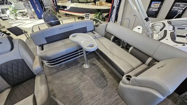 Slide: The Image of 2020 Bennington SX 23 Premium boat interior with gray seating and table in showroom. - 9