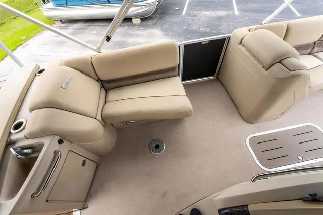 Slide: The Image of 2014 Bennington 2550 RBR boat interior with beige seating and storage compartments. - 13