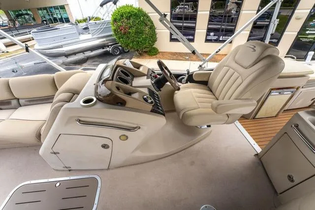 Slide: The Image of 2014 Bennington 2550 RBR boat interior with beige captain's chair and control console. - 14