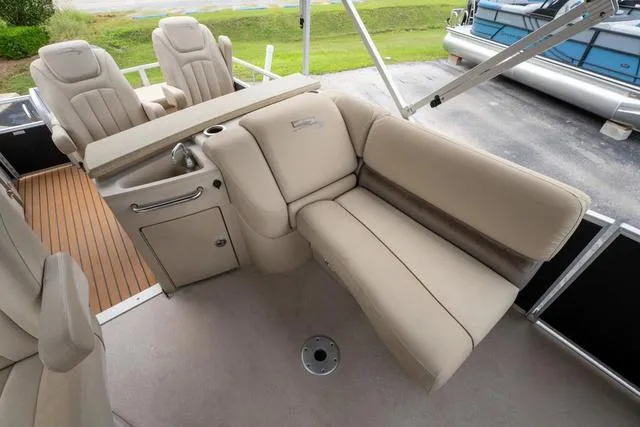 Slide: The Image of 2014 Bennington 2550 RBR boat interior with beige seating and wood accents. - 15