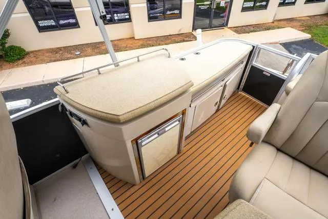 Slide: The Image of 2014 Bennington 2550 RBR boat interior with beige seating and wooden flooring. - 16