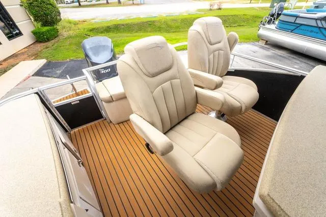 Slide: The Image of 2014 Bennington 2550 RBR boat with beige captain chairs on a wooden deck. - 17