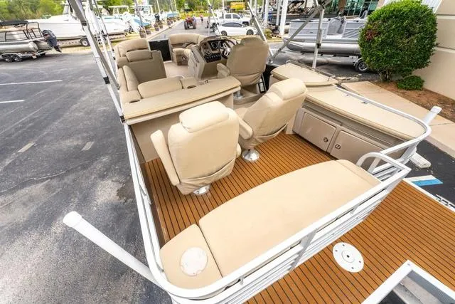 Slide: The Image of 2014 Bennington 2550 RBR pontoon boat with beige seating and wood-style flooring. - 19