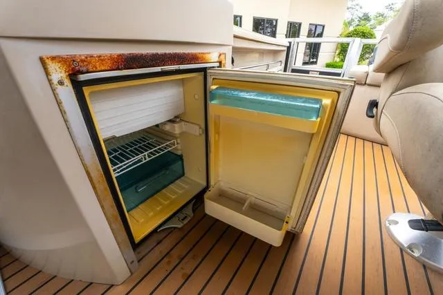 Slide: The Image of Open mini fridge on 2014 Bennington 2550 RBR boat, showing interior shelves and door compartments. - 21