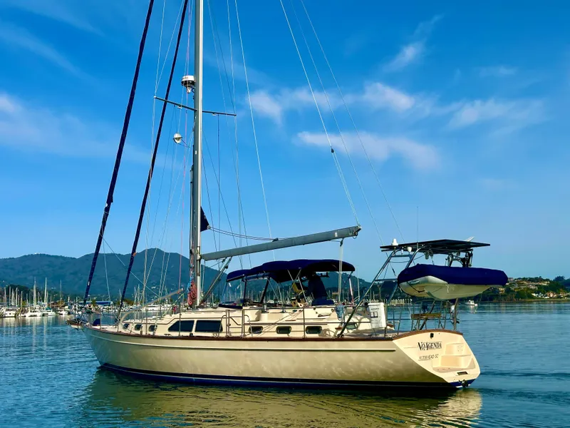 Slide: The Image of 2006 Island Packet 485 Center Cockpit sailboat on calm water, blue sky background. - 1