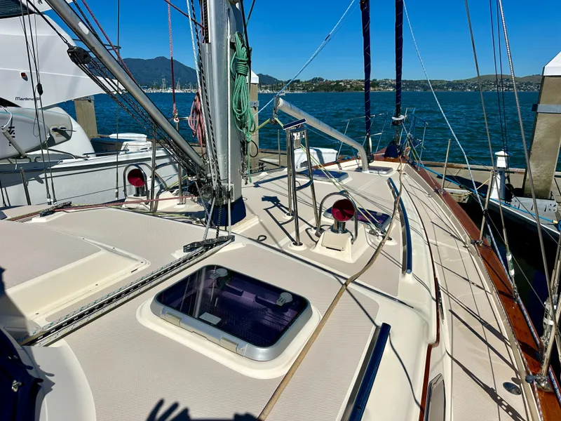 Slide: The Image of 2006 Island Packet 485 Center Cockpit sailboat docked, showcasing deck and rigging. - 11