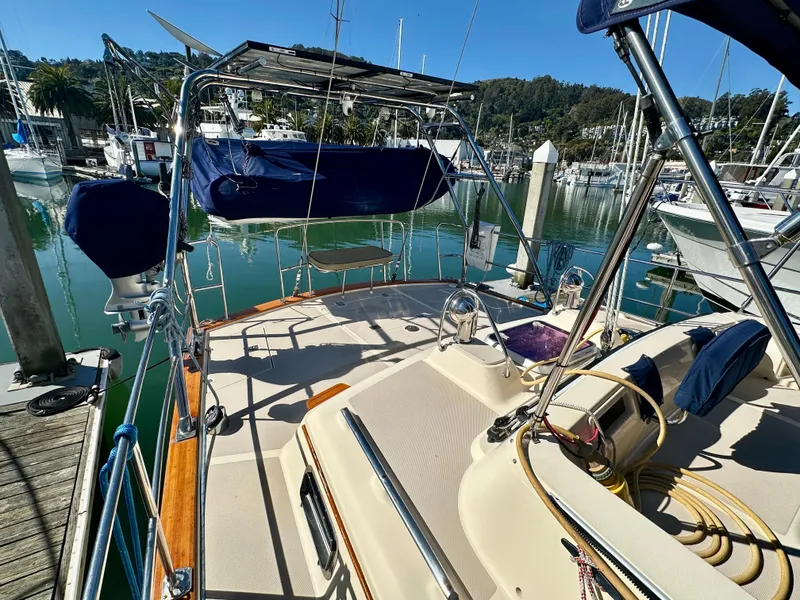 Slide: The Image of 2006 Island Packet 485 Center Cockpit sailboat docked in a marina, showcasing spacious deck. - 13