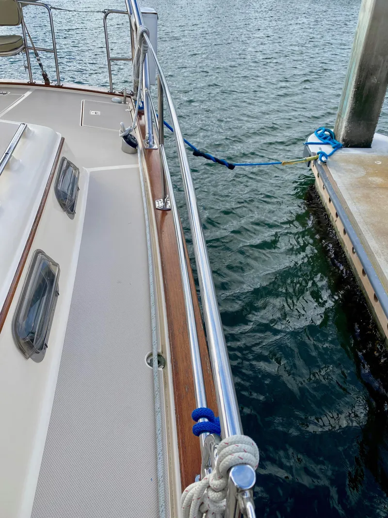 Slide: The Image of 2006 Island Packet 485 Center Cockpit yacht docked, showcasing deck and railing details. - 16