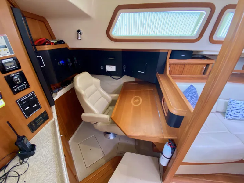 Slide: The Image of 2006 Island Packet 485 Center Cockpit interior with navigation station and seating area. - 25