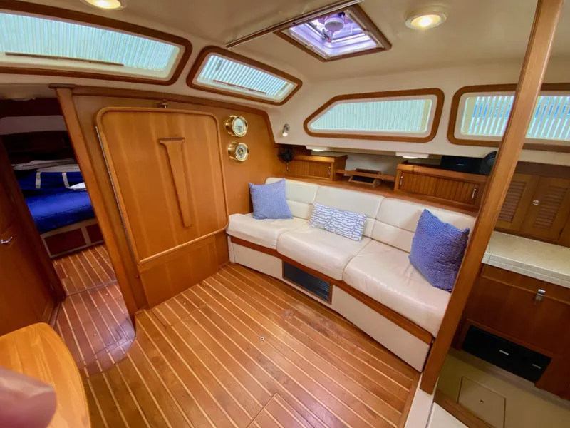 Slide: The Image of Luxurious interior of 2006 Island Packet 485 Center Cockpit with wood finish and comfortable seating. - 27